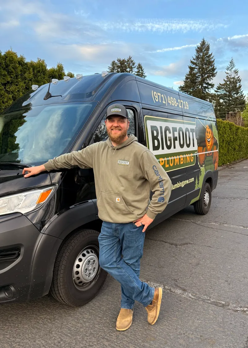 Kevin Brain, owner of Bigfoot Plumbing, standing next to his branded service van in Sandy, Oregon — family-owned local plumber serving Sandy, Boring, and Gresham OR