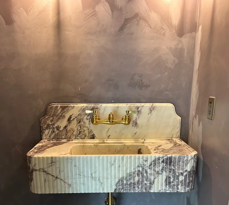 Custom marble vanity sink with brass wall-mounted faucet installed by Bigfoot Plumbing in Gresham, Oregon — fixture installation by licensed plumber CCB# 257405