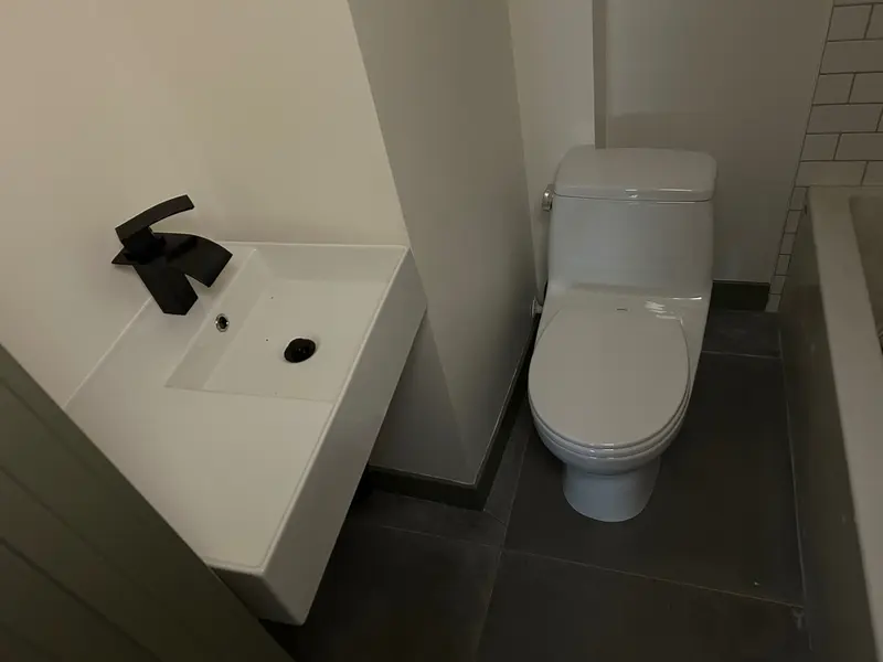 Modern bathroom remodel with floating sink, matte-black waterfall faucet, and high-efficiency toilet installation by Bigfoot Plumbing in Sandy, Oregon